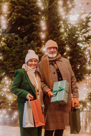 Happy senior couple enjoying christmas market, buying gifts and christmas tree.の写真素材