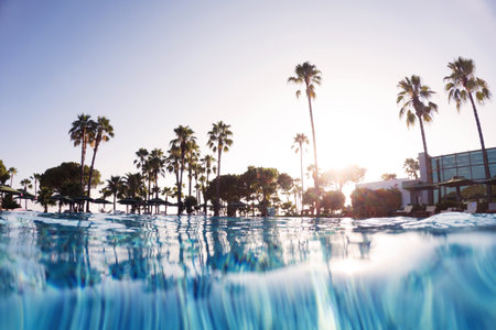 Over-under shot of hotel pool in beach resort with copy space. Beach resort vacation by the sea....