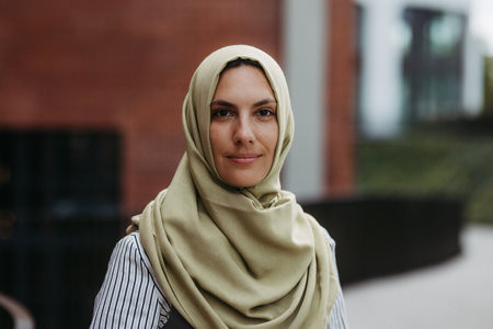 Beautiful woman in hijab standing on city street.の写真素材
