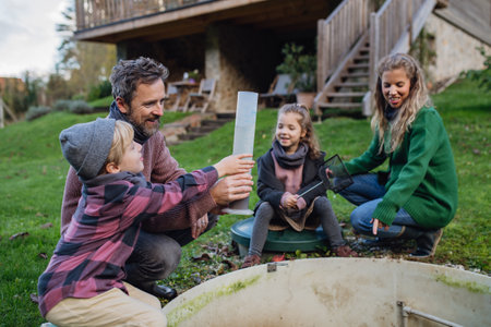The family checks the water quality in the home wastewater treatment system. Concept of sustainable family living.の写真素材
