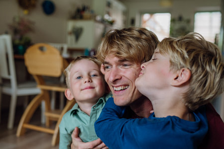 Two sons kissing fathers cheeks. Concept of Fathers Day, and fatherly love.の写真素材
