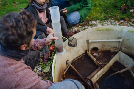 The family checks the water quality in the home wastewater treatment system. Concept of sustainable...