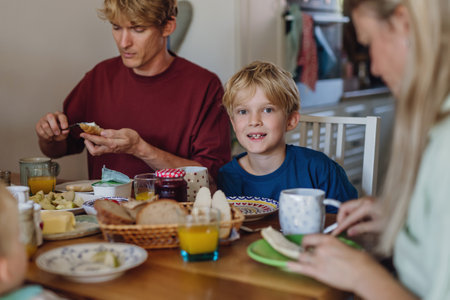 Family eating breakfast together in home kitchen. Healthy breakfast or snack before school and work.の写真素材