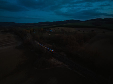 Aerial view of train in the middle of nature, field, during night.の写真素材