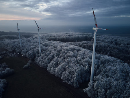 Aerial landscape photography of sunrise over frost-covered nature with wind turbines. Windmill in...