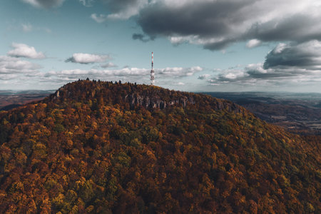 Aerial view of transmitter, cell tower surrounded by a forest and clouds, mist.の写真素材