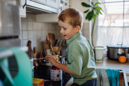 Boy helping with breakfast in home kitchen in the morning. Spending time together before going to school and work.の写真素材