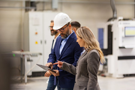 Engineer, foreman consulting with director in modern industrial factory, talking about new...