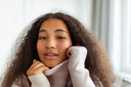 Portrait of beautiful curvy woman with beautiful curly hair, looking at camera, smiling.の写真素材