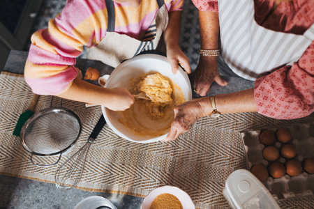 Top view of cake batter. Grandmother with grandaughter preparing traditional easter meals, baking...