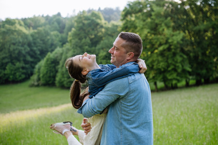 Dad with daughter, playing at meadow, hugging, having fun. Concept of fatherss Day and fatherly love.の写真素材
