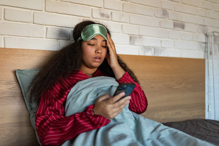 Woman setting alarm before going to sleep. Concept of sleep routine. Insomnia a sleep problems among adults.の写真素材