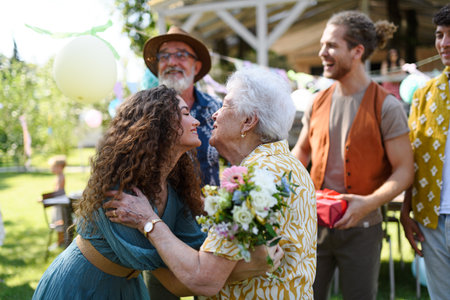 Beautiful senior birthday woman hugging her granddaughter.