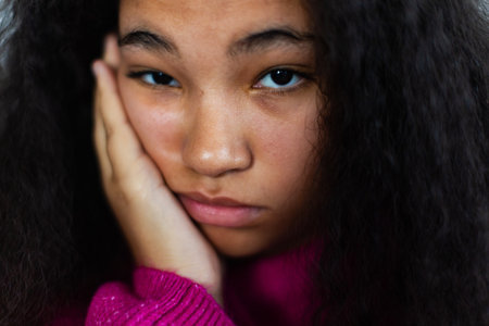 Portrait of bored woman holding her head in hand, looking at camera.の写真素材