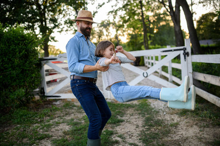 Father and young daughter having fun on family farm, farmer family. Concept of multigenerational farming.の写真素材