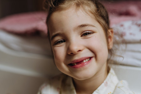 Portrait of cute girl smiling with gap-toothed grin, missing her baby teeth.の写真素材
