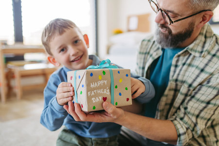 Dad get a handmade gift from little son, present wrapped in diy homemade wrapping paper. Happy Fathers day concept.の写真素材