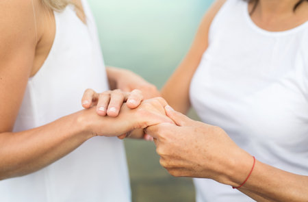 Close up of mother and daughter holding hands.の写真素材
