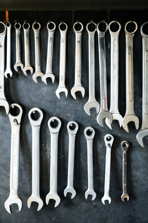 Combination wrenches set in auto repair shop. Mechanics repairing, maintaining car in garage.の写真素材