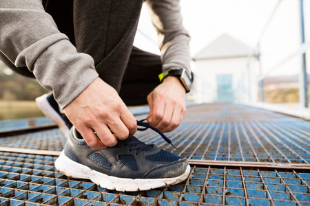 Close-up of running sneakers dirty after a run in spring nature. Tying shoelaces
