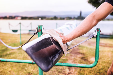 Young canoeist taking care of his canoe and paddle, cleaning, drying. Concept of canoeing as dynamic and adventurous sport. Close up.の写真素材