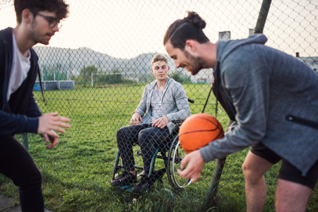 Disabled young man feeling excluded, want to play basketball with his friends, but because of...