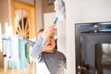 Little boy helping mother with hosehold chores, dusting cleaning their house. Weekly chores, weekend activities.の写真素材