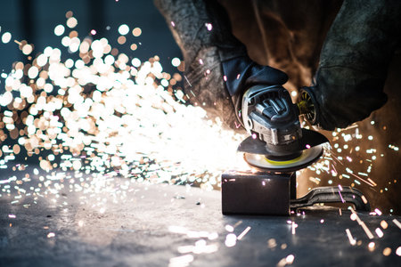 Close up of work of welder in workshop, operating welding machine, wearing protective clothing and a...