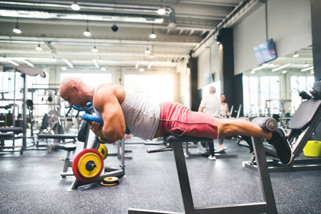 Strong man exercising in gym. Routine workout for physical and mental health.の写真素材