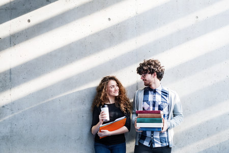 Young university students, holding stack of books, preparing for final exam. Study group.