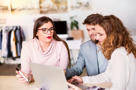 Young group of colleagues working on a new project together in a startup company office. Working in co-working space.の写真素材