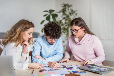 Young group of colleagues working on a new project together in a startup company office. Working in...