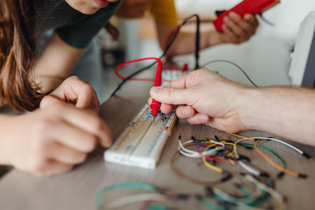 Two classmates working together on circuit board, building robot in after-school robotics club. Children learning robotics in Elementary school.の写真素材