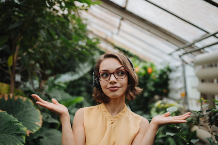 Beautiful woman standing in botanical garden, in the middle of lush green foliage.の写真素材