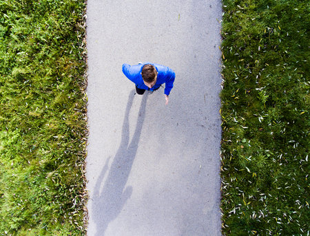 Aerial view of a runner running through the park on a jogging path. Morning running training.の写真素材