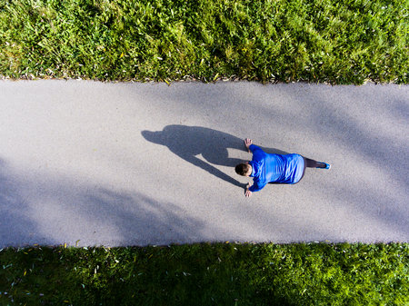 Aerial view of a runner in starting position. Man running through the park on a jogging path. Morning running training.の写真素材