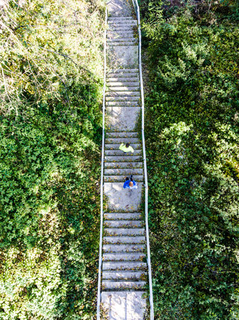 Aerial view of two runners running up the staris in the park. Morning running training for male friends.の写真素材
