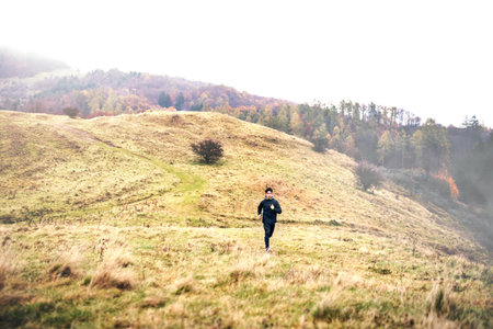 Male runner jogging in nature on dirt running trail. Morning running training for young man.の写真素材