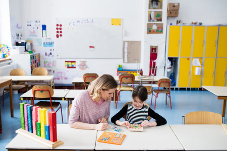 Teacher using geoboard in class, teaching students, explaining geometry, shapes, fractions or patterns. Using education tools in elementary school.の写真素材