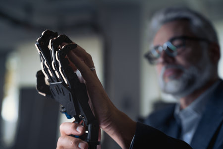 Robotics engineer adjusting, calibring robotic prosthetic hand. Concept of modern technology in medicine. Robotic prosthetics, biomechatronics and neuroscience.の写真素材