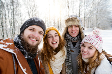 Group of friends on a walk in the snowy nature. First snowfall of the season.の写真素材