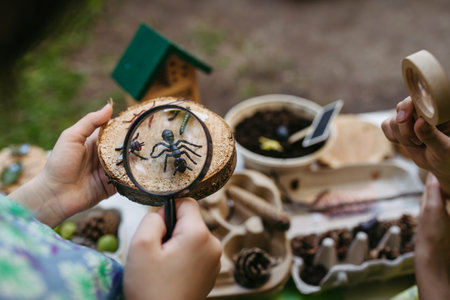 Children looking at models of insect, learning about wildlife during outdoor sustainable educational...