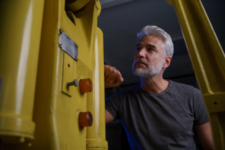 Engineer checking, servicing robotic arm. Concept of modern technology in industries, automated...