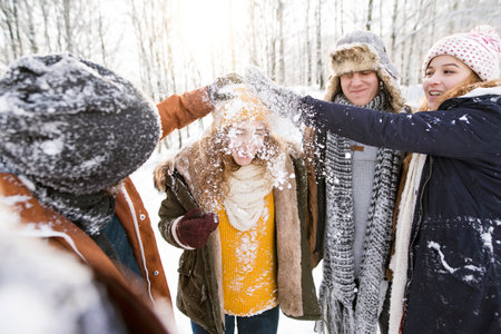 Friends in snowball fight in snowy nature. First snowfall of the season.