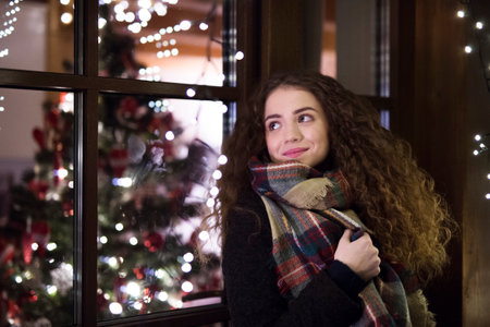 Student is coming home from university for the Christmas holidays, standing in front of house...