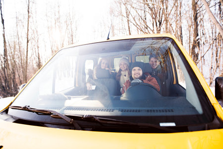 Friends traveling by car on winter holiday, spending Christmas in cabin. Driving through snowy landscape.の写真素材