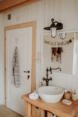 Modern attic bathroom with a wooden sink table.の写真素材