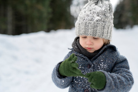 Portrait of small boy enjoying winter holiday in the mountains with family, playing in snow.の写真素材