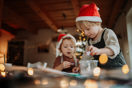 Siblings making holiday Christmas cards for family. Children painting pictures for Santa Claus or making christmas decorations with tempera paints.の写真素材
