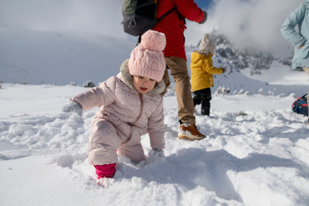 Young family is enjoying winter holiday in the mountains, playing in snow, having fun.の写真素材